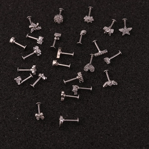 Assorted stainless steel labret studs with zircon star and heart shapes on black background