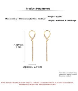 Detailed view of 925 silver needle drop earrings with crystals and long tassels