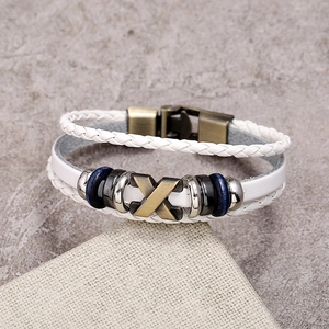Close-up of white layered leather bracelet with bronze metal X slider and beaded details