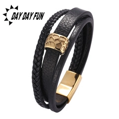 Detail of multi-layer black braided leather bracelet with golden honeycomb bead and magnetic clasp