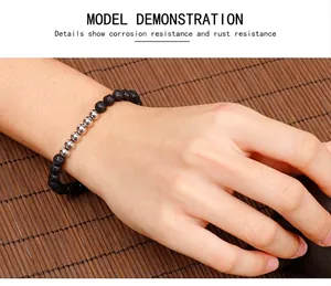 Detailed view of black lava stone bead bracelet with silver steel accents on wrist