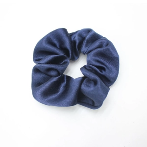 Detailed close-up of dark blue crystal satin scrunchie showing glossy silk texture