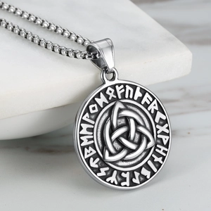 Macro detail of Nordic rune pendant with Celtic knot on aged silver stainless steel