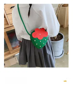 Detailed back view of green strawberry-shaped kids crossbody bag with rhinestone accents