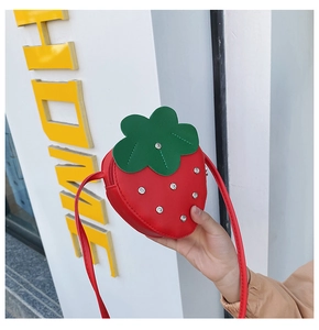 Detail of red strawberry crossbody bag with green leaf top and sparkling rhinestone studs