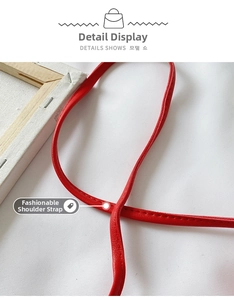 Close-up of red synthetic leather shoulder strap with neat stitching on child strawberry bag