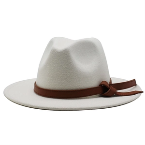 Detail of white wool fedora hat featuring a brown leather band and side knot accent
