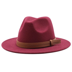 Detail view of the burgundy wool fedora hat featuring a brown leather decorative band