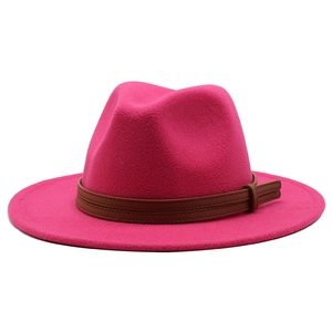 Detail of rose red fedora hat featuring a brown leather decorative band and buckle