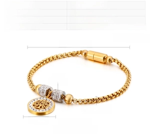 Detail view of gold stainless steel tree of life bracelet with cubic zirconia charms