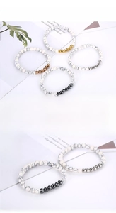 Close-up of white turquoise bead bracelets with multi-colored metallic spacer beads