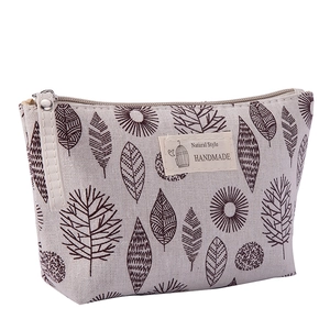 Detail of canvas makeup bag with brown leaf pattern and Natural Style handmade label