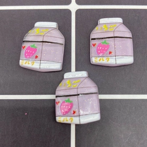 Close-up of strawberry milk box resin charms with glitter for DIY accessories