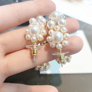 Detailed view of pearl flower stud earrings with a gold finish and cluster design