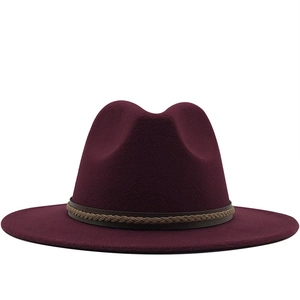Detail van bordeauxrode wollen fedora hoed met een lichtbruine geweven decoratieve band