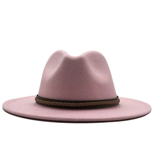 Detail van roze wollen fedora hoed met een bruine gevlochten leren band op witte achtergrond
