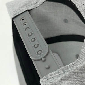 Detail of adjustable snapback closure on gray hip-hop baseball cap with high texture fabric