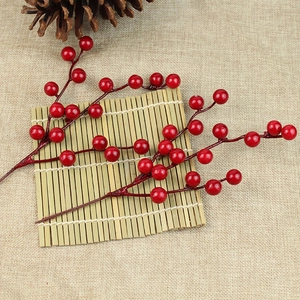 Close-up of artificial Christmas red berries on a rustic bamboo mat background