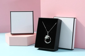 Detailed view of silver leopard head necklace with sparkling crystals in black gift box