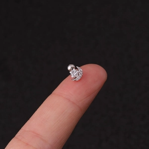Macro shot of silver star and moon screw back stud earrings with clear zircon on fingertip