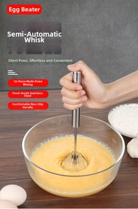Action shot of semi-automatic stainless steel whisk rotating in a glass mixing bowl