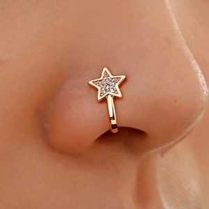 Macro shot of a gold star nose cuff with clear zircon stones on a female model