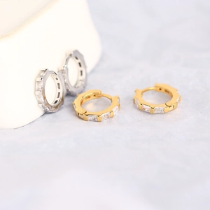 Detailed macro view of S925 silver earring hoops with square zircon in gold and silver finish