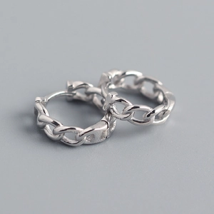 Macro shot of silver chain link hoop earrings showing polished metal texture