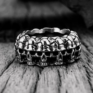 Detailed macro view of vintage gothic skull relief ring on dark textured wood surface