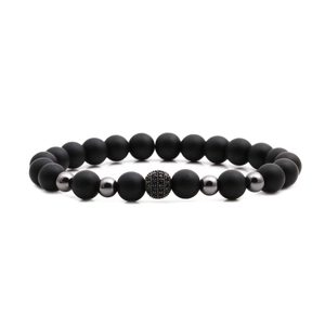 Matte black stone bead bracelet featuring a gunmetal pave zircon charm on white background