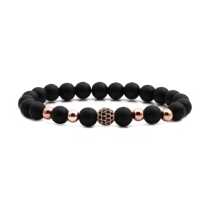 Macro detail of matte black stone beads and rose gold accents on a beaded bracelet