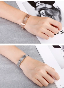 Vue détaillée des bracelets en maille or rose et argent avec breloques trèfle et fleur