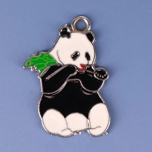Cute black and white panda metal pendant with green bamboo leaf on blue background