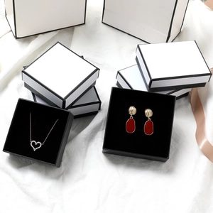 White jewelry gift box with black trim and velvet lining for necklaces and earrings
