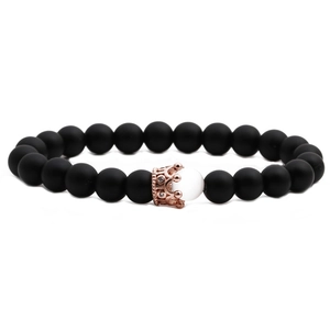 Matte black stone crown bracelet with white cat eye bead on a white background