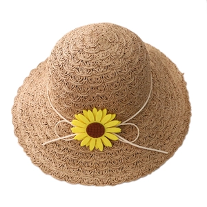 Straw sun hat for women with a yellow sunflower decoration on white background