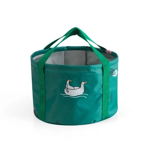 Detail of portable green folding basin with cartoon duck print and sturdy webbed handles