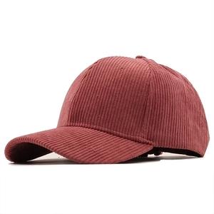 Detailed close-up of retro corduroy fabric texture on a vintage baseball cap in dark red