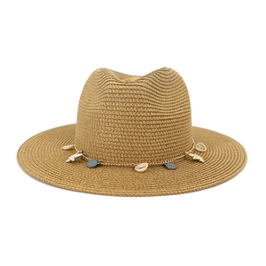 Detalle de sombrero de paja caqui con dijes de conchas y estrellas de mar en cadena metálica
