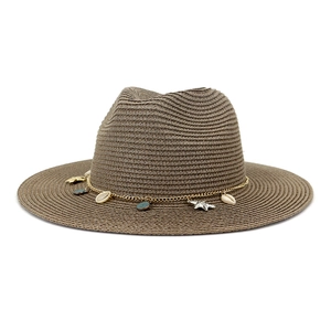 Detalle de sombrero de paja café con cadena dorada, conchas y estrellas de mar