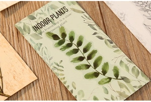 Close-up of indoor plants PET stickers featuring green leaf prints on a wooden table