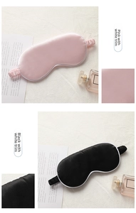 Detail of pink and black silk sleep masks with white piping and elastic headbands