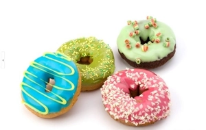 Top view of four colorful decorated donuts on a white background with vivid frosting details
