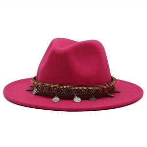 Detail of fuchsia wool fedora hat featuring ethnic woven band and silver metal charms