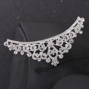 Close-up of elegant silver crown hair comb with sparkling rhinestones on dark background