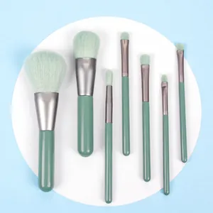 Detailed flat lay of 7-piece mini makeup brush set in mint green and emerald wood handles