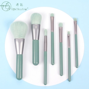 Detailed flat lay of 7-piece mini makeup brush set in mint green and emerald wood handles