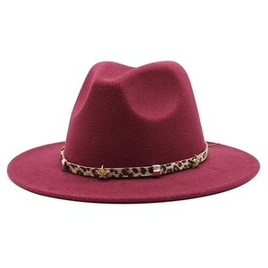 Detail of burgundy wool fedora featuring a leopard print band and gold star ornament