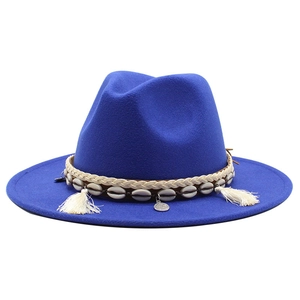 Royal blue wool fedora hat with ethnic woven band, sea shells and tassels on white background