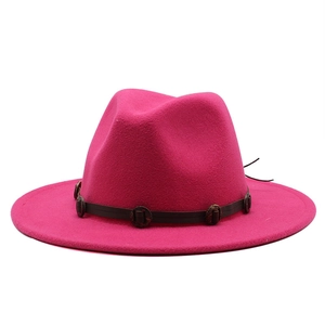 Close-up of fuchsia wool fedora hat with vintage leather band and metal buckle detail